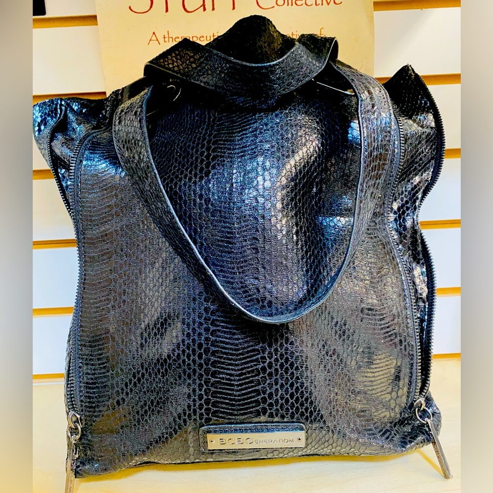 Snakeskin, silver hardware, bilateral zippers allow for size expansion